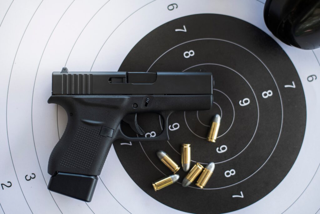 Pistola e munições sobre alvo de tiro