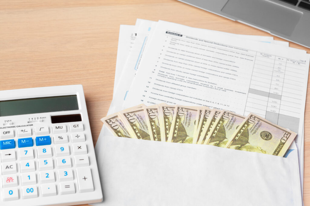 Calculadora, formulários e dinheiro sobre a mesa