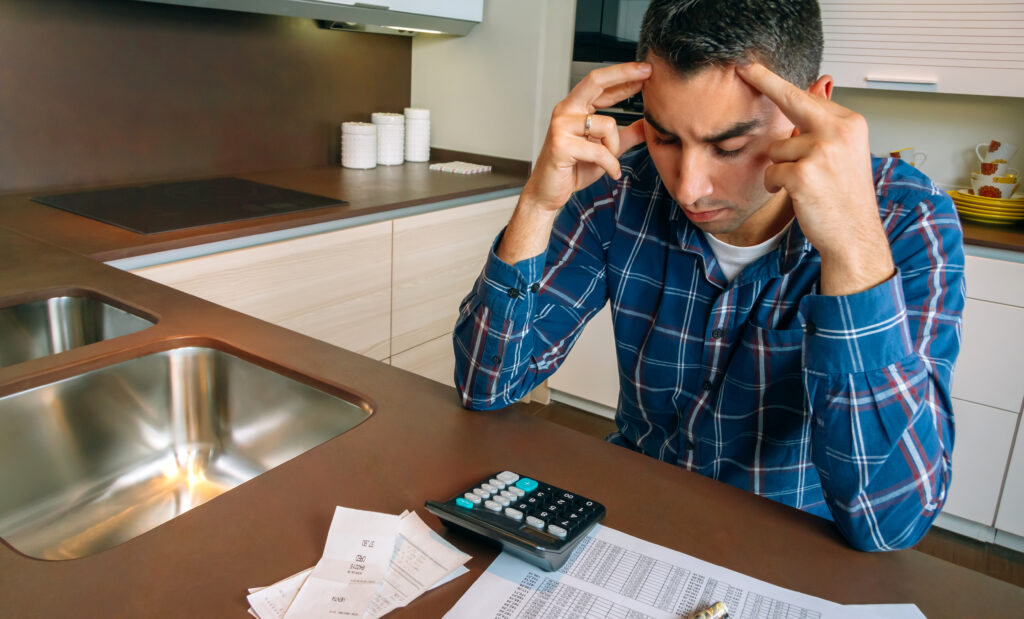Homem analisa contas e finanças na cozinha