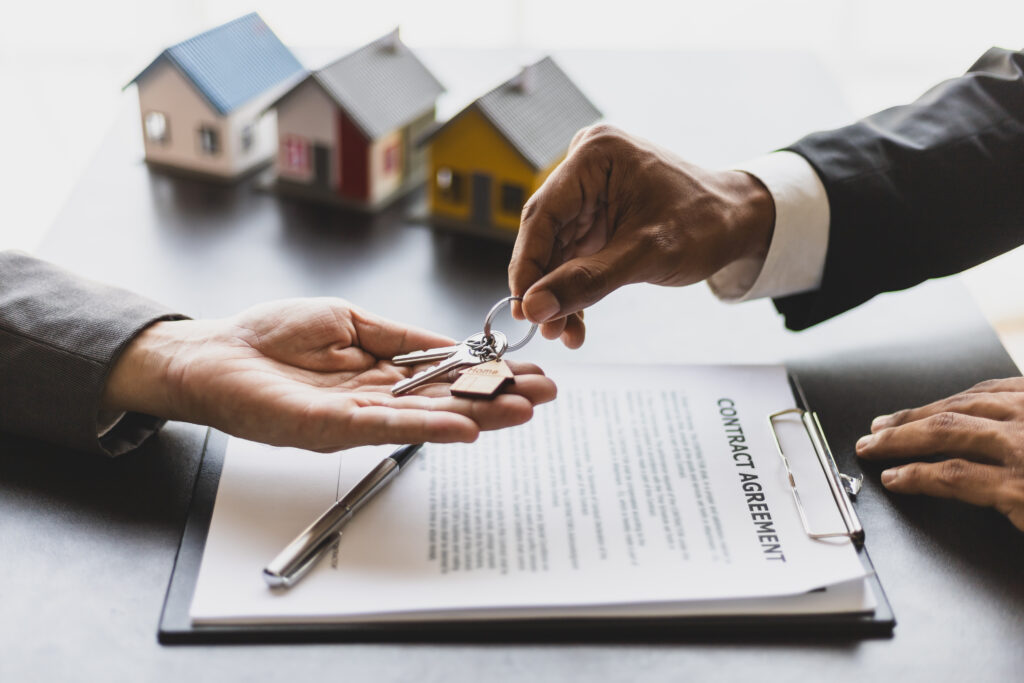Contrato imobiliário com maquetes de casas e chaves